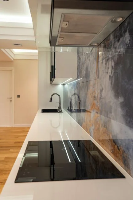 Un couple prend plaisir à emménager dans une nouvelle maison, entouré de cartons et d’un décor minimaliste.